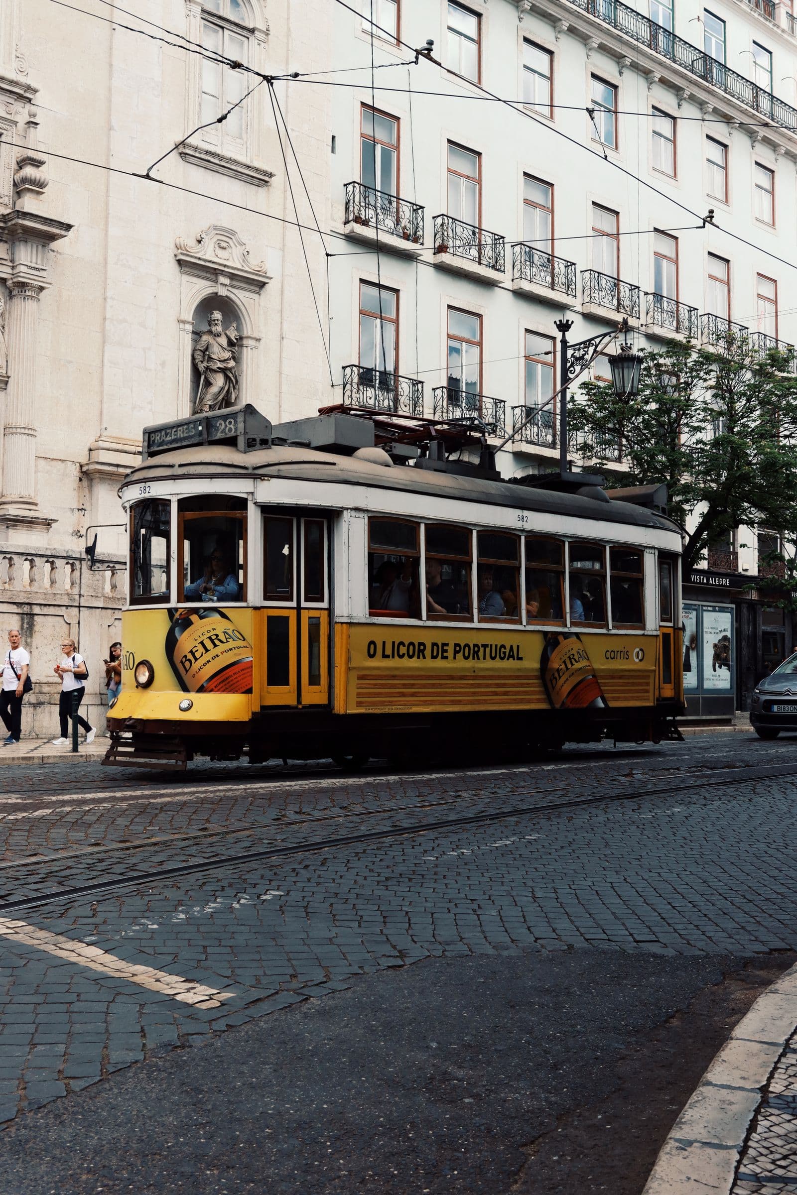 A yellow tram on a street in Lisbon